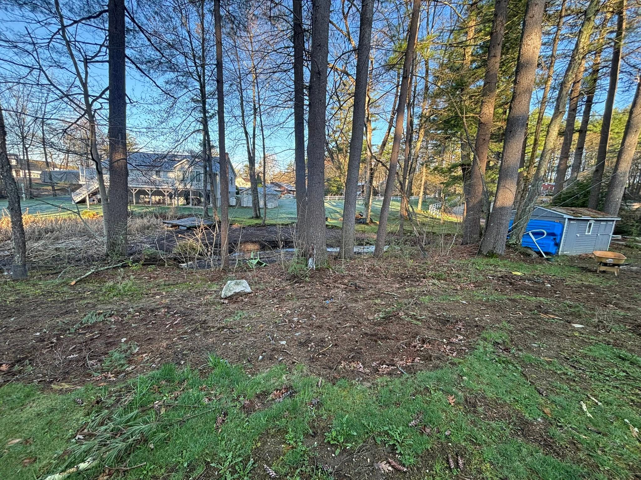 Concrete pad against rock wall causing water pooling